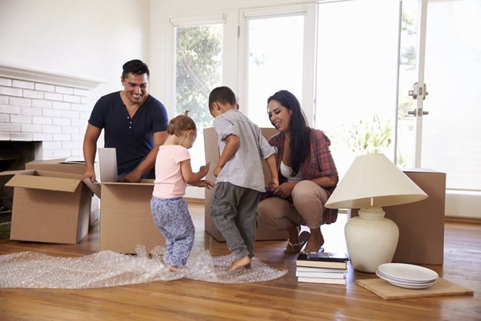 Young family standing outside of their home