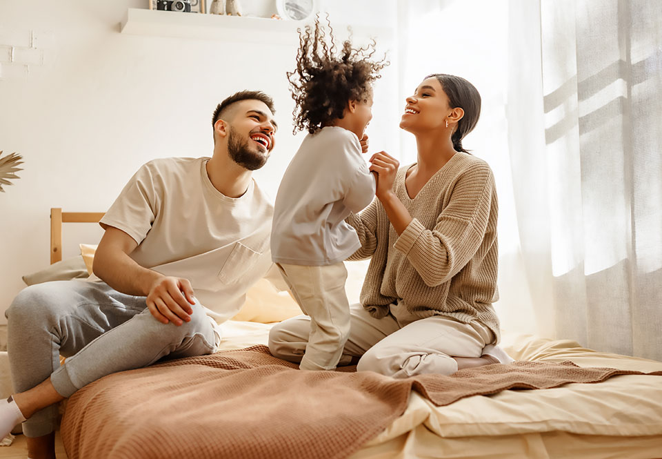 Family playing on a bed