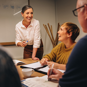 woman smiling at her coworkers during meeting