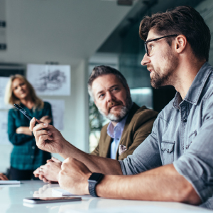 two men talking with woman behind them