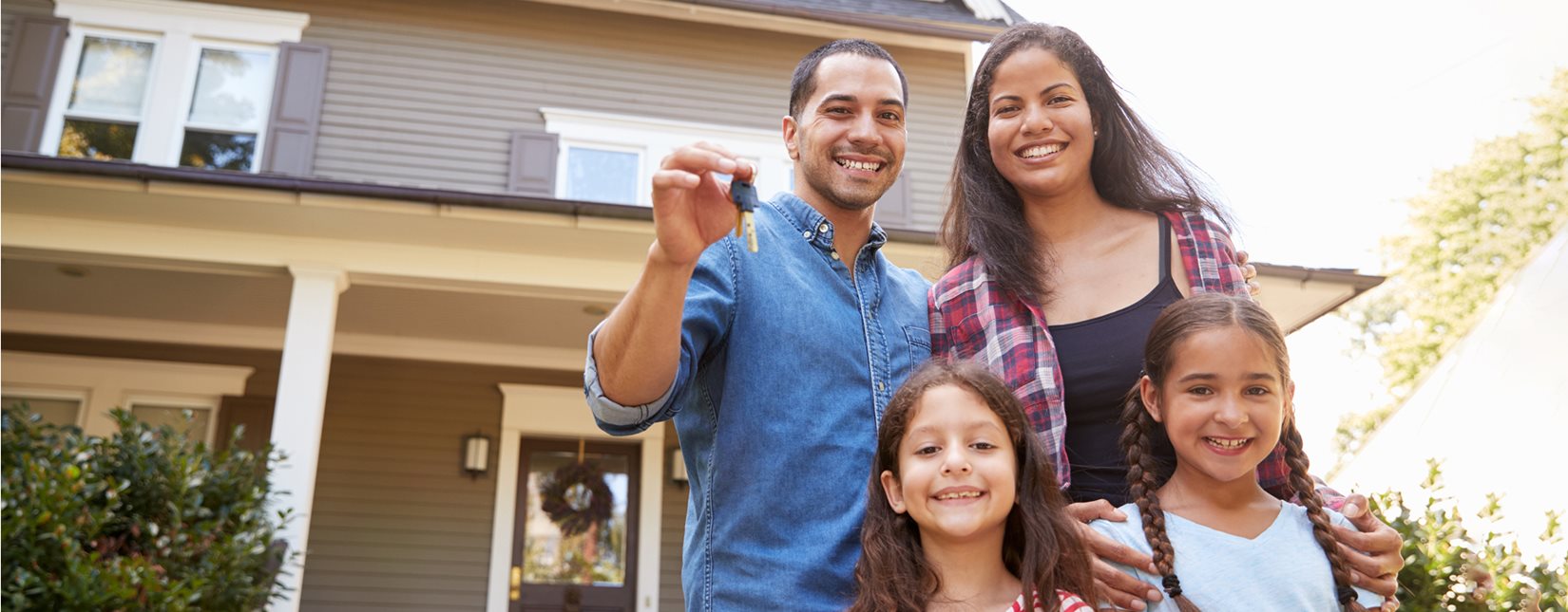 man holding keys with family