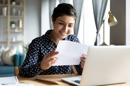 Woman smiling while holding a paper