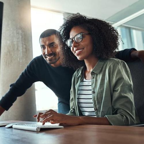 woman on computer with man watching